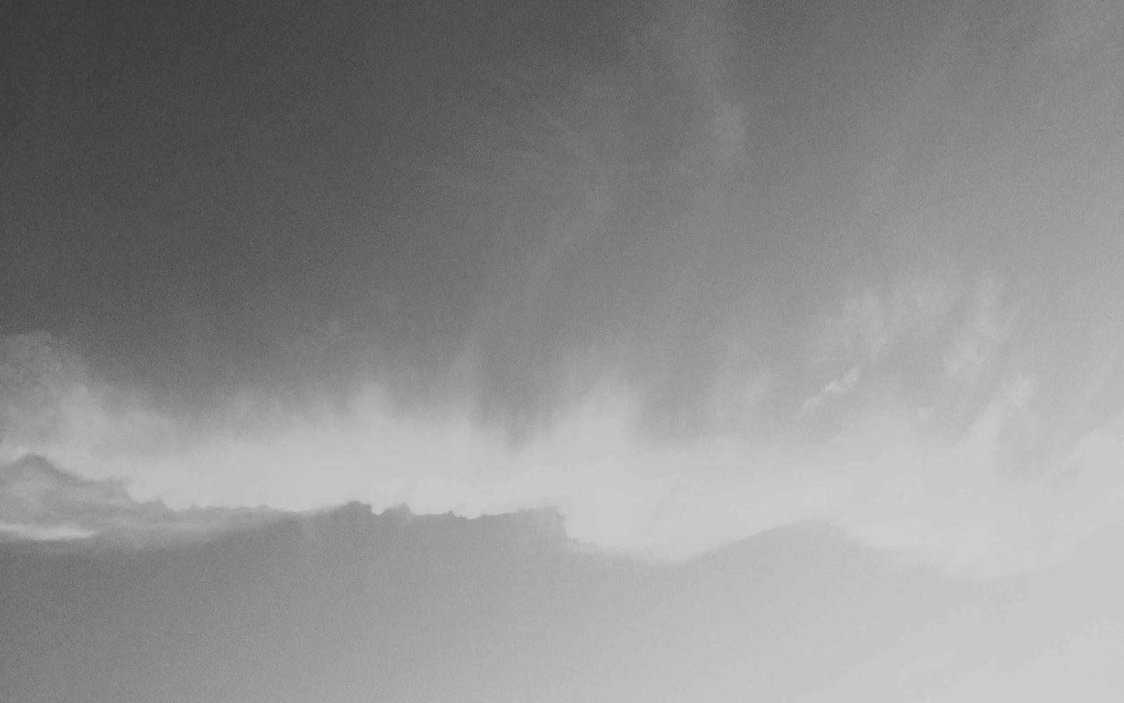 An empty mountain ridge beneath heavy storm clouds